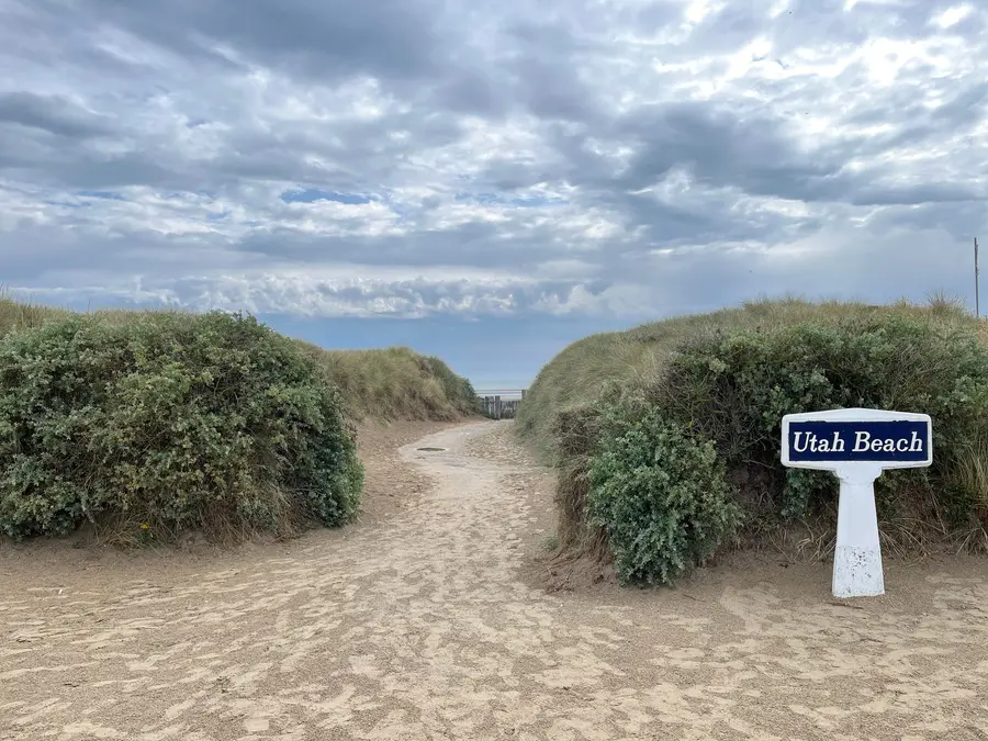 A sandy path through dune grass leading from the Utah Beach museum down to the shoreline.